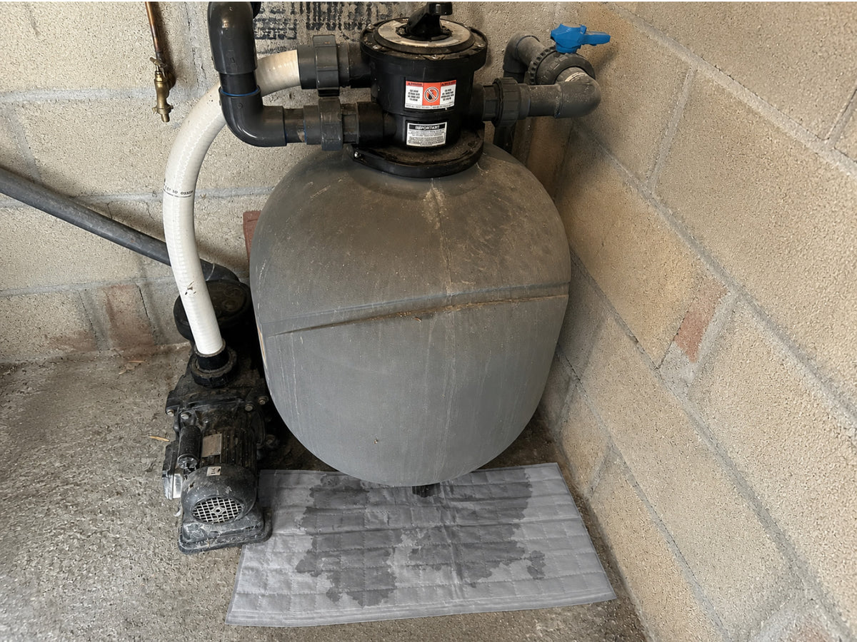 Mise en place d'un sac absorbant OBLOC® sous un filtre piscine avec une fuite en goutte à goutte