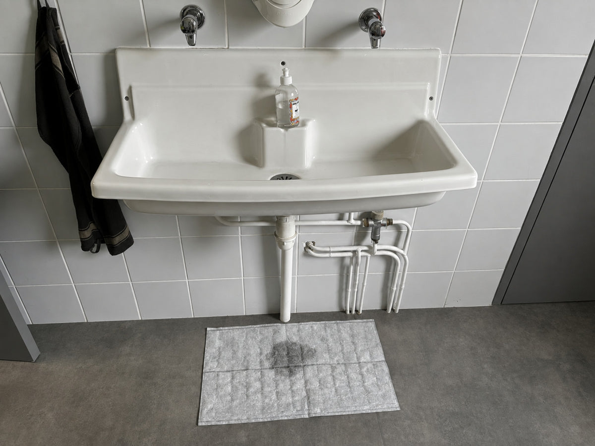 Installation d'un sac absorbant OBLOC® sous un évier présentant une fuite